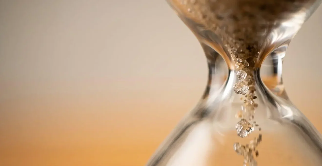 Hourglass with sand flowing representing data retention time limits and compliance deadlines